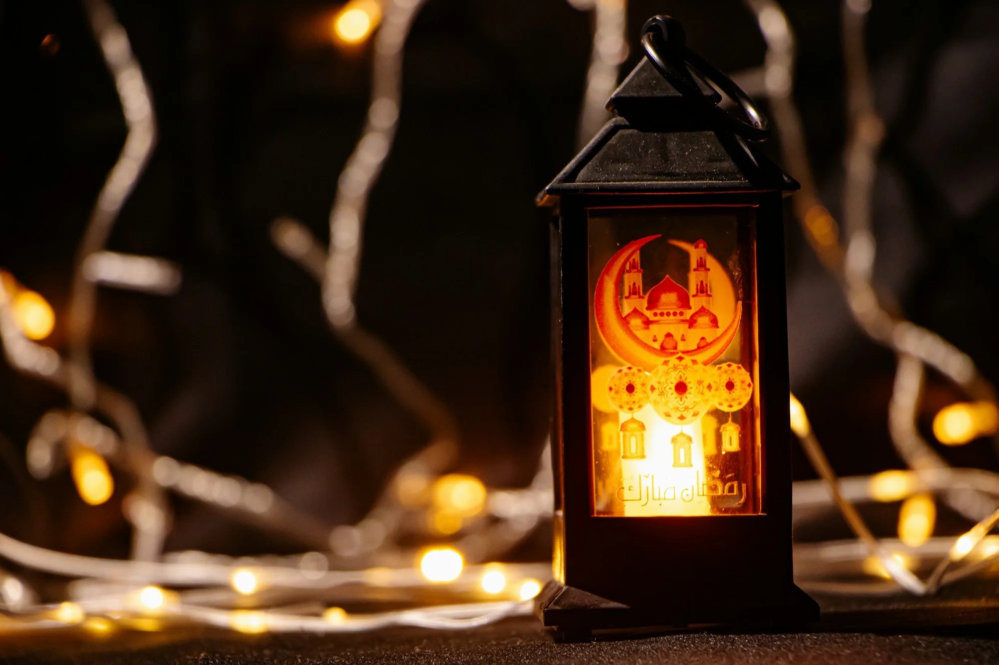 Ramadan lantern glowing among string lights at night